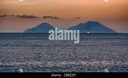 Silhouette delle Isole Eolie nella calda e colorata luce del tramonto invernale. Sicilia, Italia, Europa Foto Stock