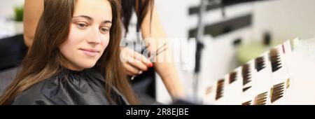 La clientela femminile sceglie in catalogo tinture e colori per la colorazione dei capelli Foto Stock