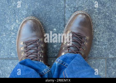 Un uomo è in piedi in scarpe da turismo su una lastra di pietra Foto Stock