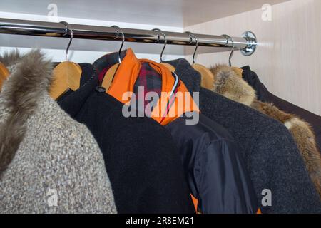 Armadio aperto con vestiti su appendiabiti e disordine in cassetti aperti  Foto stock - Alamy