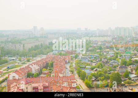 fumo di smog in città. panorama della città, casa cittadina, case, alberi, strada. fumo da incendi boschivi, cattiva ecologia Foto Stock