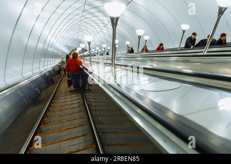 scala mobile per metropolitana, interni in metallo, lampade. le persone salgono sulla scala mobile. San Pietroburgo, Russia - 5.7.22 Foto Stock