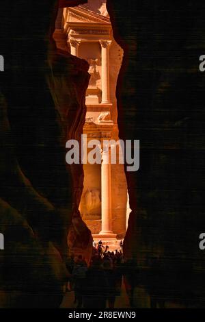 Petra, Giordania - 3 novembre 2022: Persone che entrano nel Tesoro, al Khazneh, pareti del canyon Siq e vista sull'edificio Foto Stock