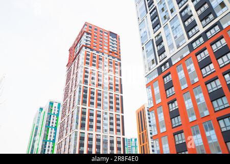 multicolor moderni edifici di appartamenti, torri, grattacieli su cielo nuvoloso bianco, complesso residenziale. vista dal basso dalla strada. Foto Stock