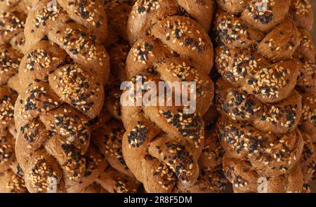 Un colpo in testa di un pane di sesamo appena sfornato, tre forme intricate intrecciate e cosparse di semi di sesamo Foto Stock