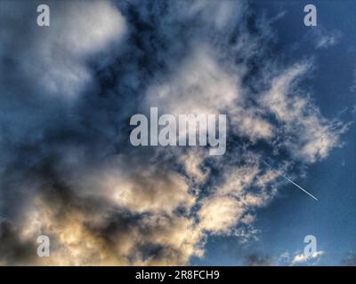 Un aereo che vola nel cielo in una giornata nuvolosa Foto Stock