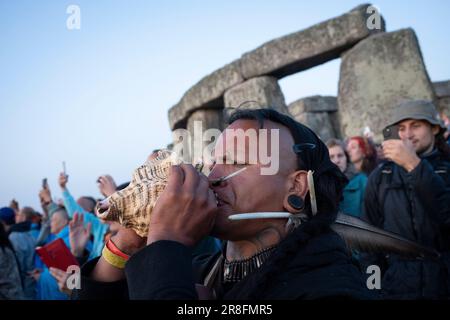 I festeggiatori spiritualmente attenti celebrano il Solstizio d'estate (metà estate e giorno più lungo) presso le antiche pietre tardo-neolitiche di Stonehenge, il 21st giugno 2023, a Wiltshire, Inghilterra. Il solstizio d'estate è il giorno più lungo dell'emisfero settentrionale e la notte più breve dell'anno, quando l'asse della terra è inclinato nel suo punto più vicino al sole e i pagani dicono che l'antico monumento è un luogo sacro che collega la Terra, la Luna, il Sole e le stagioni. Stonehenge fu costruita in tre fasi tra il 3.000 a.C. e il 1.600 a.C. Stonehenge è di proprietà del patrimonio inglese che dice che 8.000 visitatori sono stati ammessi nel Foto Stock