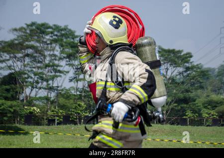 Bandung, Indonesia. 21st giugno, 2023. Un vigile del fuoco partecipa a un concorso di abilità antincendio a Soreang di Bandung, Giava Occidentale, Indonesia, 21 giugno 2023. Credit: Seppianjar Muharam/Xinhua/Alamy Live News Foto Stock