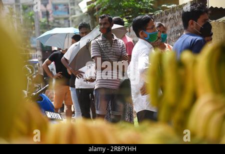 I beneficiari aspettano in coda per ricevere la dose di vaccino contro il coronavirus COVID-19 durante una campagna di vaccinazione a Guwahati, India, lunedì 21 giugno 2021 Foto Stock