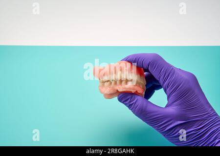 Tecnico odontoiatrico che fa protesi dentaria fatta a mano in Un'officina di lavoro Foto Stock