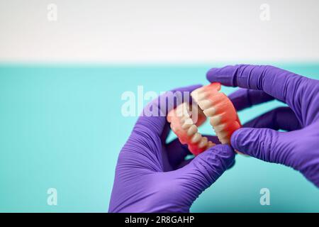 Tecnico odontoiatrico che fa protesi dentaria fatta a mano in Un'officina di lavoro Foto Stock