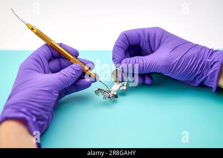 Un tecnico dentistico che fa nuove protesi dentarie in laboratorio. Foto Stock