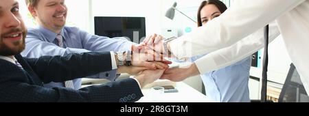 Team aziendale internazionale che mostra unità con le mani insieme Foto Stock