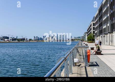 Le persone sedute sulla panchina godono della vista del molo in una giornata di sole al molo Royal Albert Foto Stock