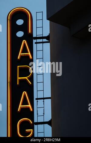 Porto, Portogallo - 24 aprile, 2023: Primo piano dettaglio al crepuscolo delle lettere illuminate sul segno neon ortografia 'Garage' sulla parete del parcheggio pubblico in centro Foto Stock