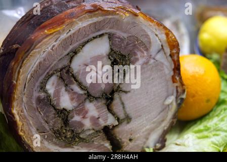 Arrosto di Porchetta arrotolato fatto in casa, asse di legno, porchetta italiana su un vassoio Foto Stock