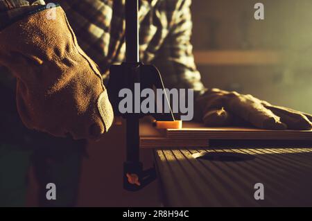 Primo piano del morsetto per lavorazione del legno montato da un operatore di legno professionista nella sua officina. Tema delle attrezzature da costruzione. Foto Stock