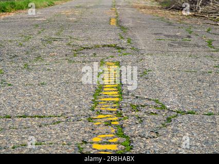 Questa foto mostra una vecchia strada di campagna con una linea gialla che delimita il centro Foto Stock