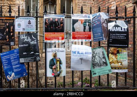 Poster che pubblicizzano spettacoli teatrali e concerti musicali sono attaccati alle ringhiere di ferro a Trinity Lane, Cambridge, Regno Unito Foto Stock
