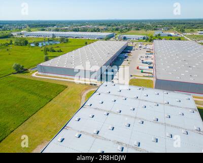 Vista aerea di merci di magazzino. Centro di logistica industriale in zona della città dall'alto. Vista aerea di camion caricamento al centro logistico. Vista da fuco Foto Stock