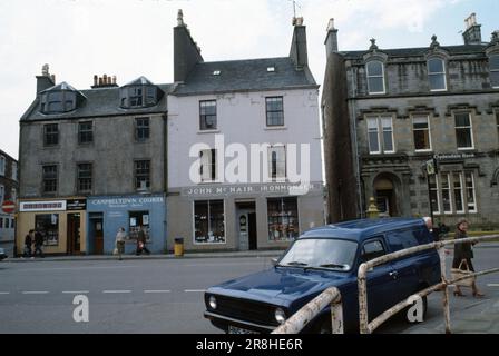 Campbeltown, Scozia, Regno Unito - Luglio 1983: Intersezione di Longrow Street e Burnside Street, viste di edifici, negozi e pedoni. Foto Stock