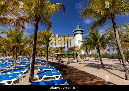 Paesaggio tropicale e faro ('faro') su Harvest Caye - isola privata di proprietà della Norwegian Cruise Line in Belize Foto Stock