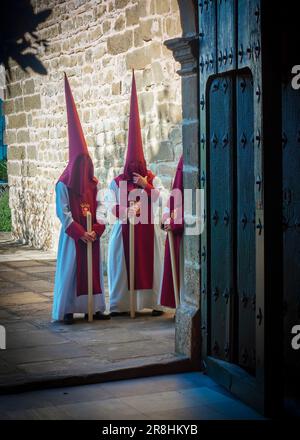 Nazareni con tunica e cappuccio nelle processioni per le strade di Baeza durante la celebrazione della sua tradizionale settimana Santa. Foto Stock