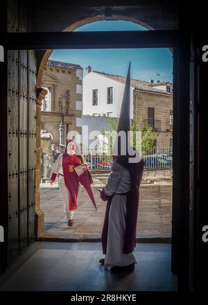 Nazareni con tunica e cappuccio nelle processioni per le strade di Baeza durante la celebrazione della sua tradizionale settimana Santa. Foto Stock