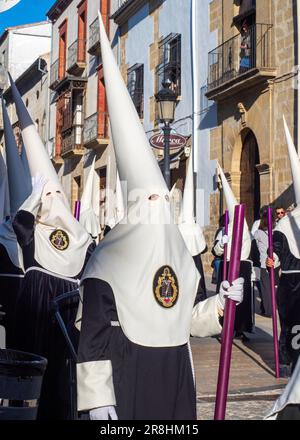 Nazareni con tunica e cappuccio nelle processioni per le strade di Baeza durante la celebrazione della sua tradizionale settimana Santa. Foto Stock