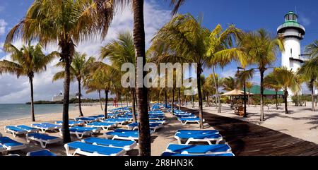 Paesaggio tropicale e faro ('faro') su Harvest Caye - isola privata di proprietà della Norwegian Cruise Line in Belize Foto Stock