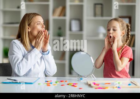 Formazione vocale per bambini. Bambino professionista specialista donna formazione con la bambina Foto Stock