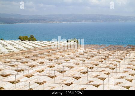 Vista dall'alto dei tetti delle serre con finestre di ventilazione aperte vicino alla costa del Mediterraneo Foto Stock