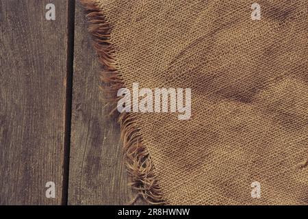 il burlap si trova su un vecchio pavimento di legno per lo sfondo, sfondo di legno con tessuto Foto Stock