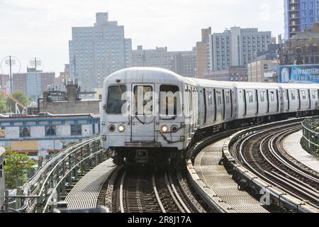 Q treno che arriva alla stazione di Stillwell Avenue a Coney Island a Brooklyn, New York. Foto Stock