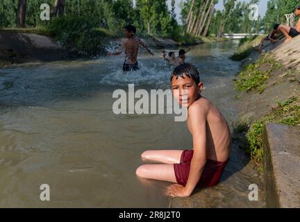 Pulwama, India. 21st giugno, 2023. Un ragazzo di Kashmiri si guarda mentre si bagna in un canale durante una calda giornata a Srinagar. La temperatura massima in Srinagar è aumentata a 34,0°C ed è stata di 4,8°C al di sopra della norma per la stagione. La temperatura di oggi ha superato il precedente più alto di 33,3°C registrato solo ieri, ha detto l'ufficiale. (Foto di Idrees Abbas/SOPA Images/Sipa USA) Credit: Sipa USA/Alamy Live News Foto Stock