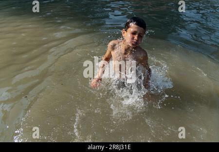 Pulwama, India. 21st giugno, 2023. Un ragazzo di Kashmiri ha visto fare il bagno in un canale durante una giornata calda a Srinagar. La temperatura massima in Srinagar è aumentata a 34,0°C ed è stata di 4,8°C al di sopra della norma per la stagione. La temperatura di oggi ha superato il precedente più alto di 33,3°C registrato solo ieri, ha detto l'ufficiale. (Foto di Idrees Abbas/SOPA Images/Sipa USA) Credit: Sipa USA/Alamy Live News Foto Stock