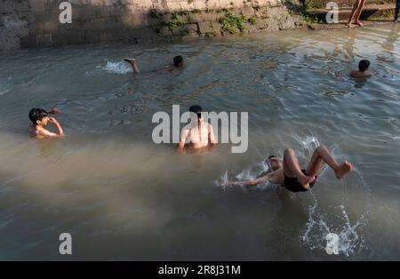 Pulwama, India. 21st giugno, 2023. I ragazzi di Kashmiri hanno visto fare il bagno in un canale durante una giornata calda a Srinagar. La temperatura massima in Srinagar è aumentata a 34,0°C ed è stata di 4,8°C al di sopra della norma per la stagione. La temperatura di oggi ha superato il precedente più alto di 33,3°C registrato solo ieri, ha detto l'ufficiale. (Foto di Idrees Abbas/SOPA Images/Sipa USA) Credit: Sipa USA/Alamy Live News Foto Stock