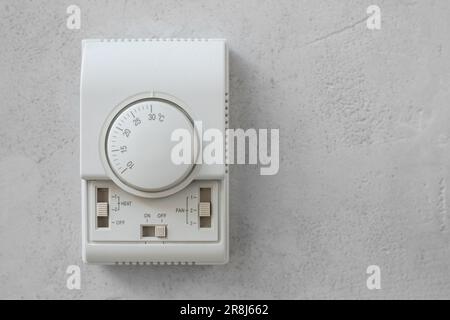 Primo piano di un pannello di controllo montato a parete per una tenda termica su parete bianca Foto Stock