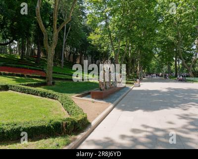 Insegna di Gulhane dipinta con fiori all'interno del parco di Gulhane a Istanbul, Turchia. la gente si siede sulle panchine all'ombra del sole estivo. Foto Stock