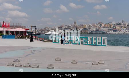 Insegna di Istanbul vicino all'incrocio tra Corno d'Oro e Bosforo con lo sfondo della Torre Galata e il ristorante Sarayburnu Aile Cay bahcesi a sinistra. Foto Stock