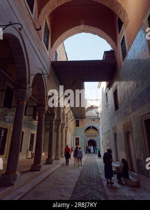 I turisti si trovano in un elegante vicolo parzialmente coperto con archi nel Palazzo Topkapi, nel quartiere di Fatih, a Istanbul, in Turchia Foto Stock