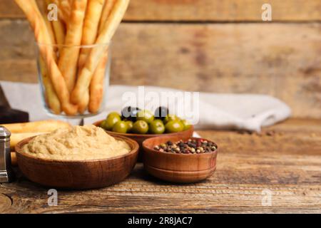 Ciotola con gustoso hummus su sfondo di legno Foto Stock