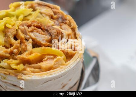 Shawarma panino arrotolato con salsa e verdure, Arab tradizionale Food. Shawarma Doner kebab wrap con pollo. Shawar tradizionale israeliano fatto in casa Foto Stock