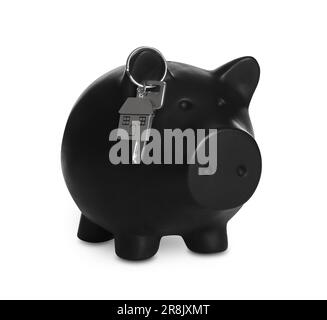 Piggy bank con chiave su sfondo bianco. Risparmio di denaro per l'acquisto di casa Foto Stock