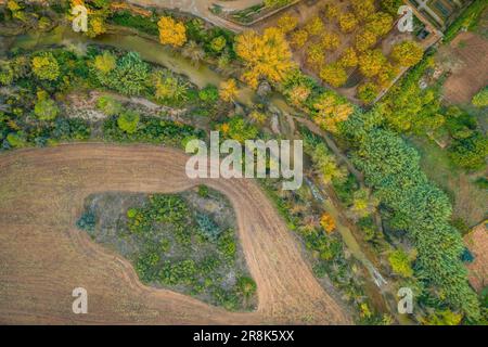 Vista aerea zenitale del fiume Algars che attraversa Arnes, in un giorno autunnale (Terra alta, Tarragona, Catalogna, Spagna) Foto Stock