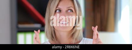 Bella donna attraversata le dita in ufficio Foto Stock