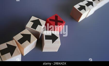 Blocchi di legno con freccia e icona di errore. Ritardi e interruzioni, interruzione del processo, concetto di errore critico Foto Stock