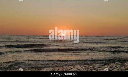 sole all'orizzonte durante il tramonto sulla spiaggia di playa sirena a corcovado Foto Stock