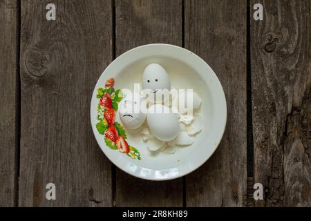 uovo di pollo triste e gioioso in un piatto nel guscio Foto Stock