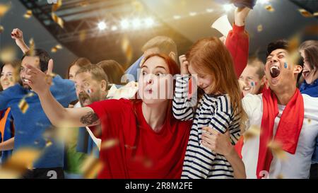 Giovane donna, fan dello sport che mostra la bambina la sua squadra di calcio preferita. Persone, tifosi di calcio che partecipano alla partita per guardare la partita e allietare la squadra Foto Stock